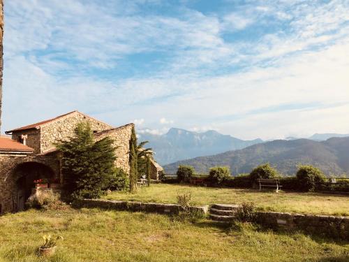 a house in a field with mountains in the background at Lover's Nest by Holiday World in Baiardo