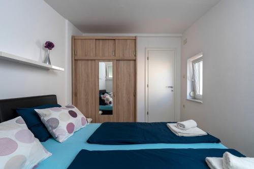a bedroom with a blue and white bed and a door at MIMOZA2 in Novi Vinodolski