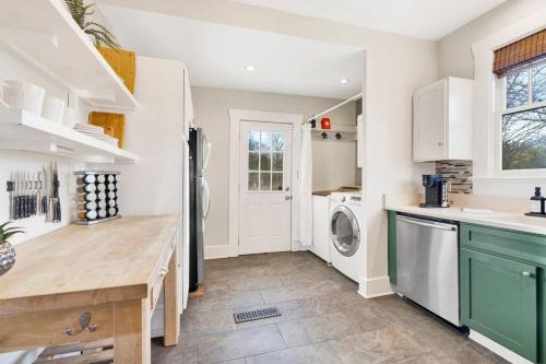 a kitchen with a refrigerator and a washer and dryer at Historic family getaway mins from downtown in Birmingham