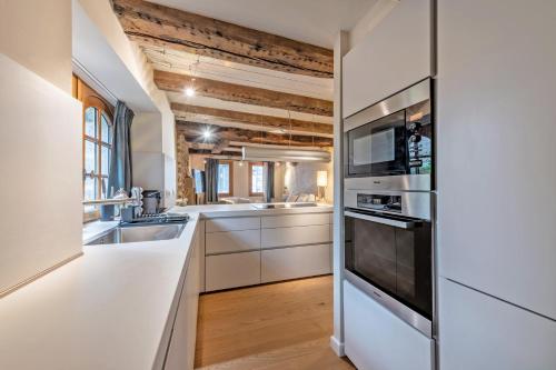 una cucina con mobili bianchi e un forno a piano cottura di Ar Barzh Kadiou II a Quimper