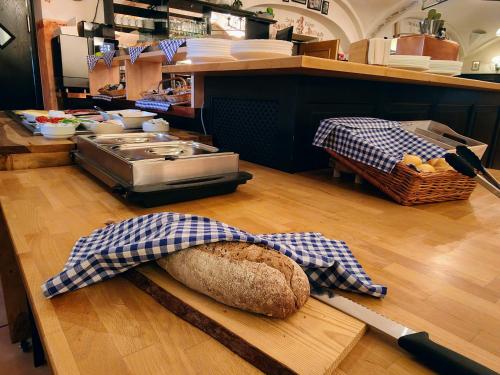una hogaza de pan en una tabla de cortar en un mostrador en A8 Hotel im Darchinger Hof, Bed & Breakfast, en Weyarn