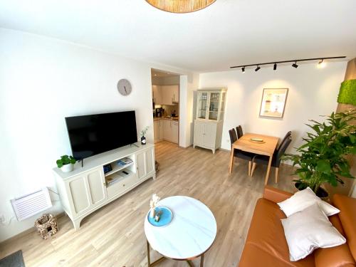a living room with a couch and a tv at Inselliebe Norderney in Norderney
