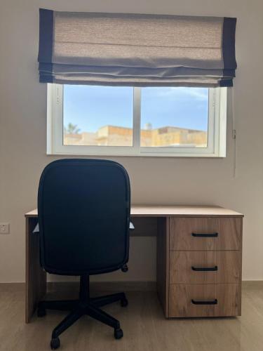 a desk with a chair in front of a window at Victoria Modern Apartment in Victoria