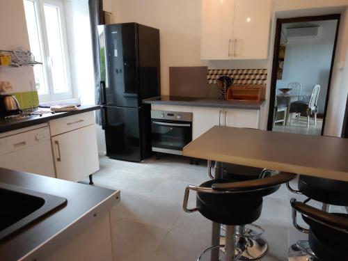 Il comprend une cuisine équipée d'un réfrigérateur noir et d'une table. dans l'établissement Maison Lisa Maria, à Ponte-Leccia