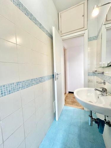 a white bathroom with a sink and a mirror at Appartamento Elena in Cefalù