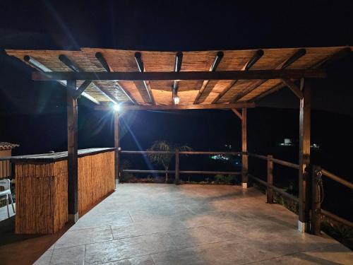 een houten pergola met 's nachts een licht erop bij Casa Rural Las 3 R in Málaga