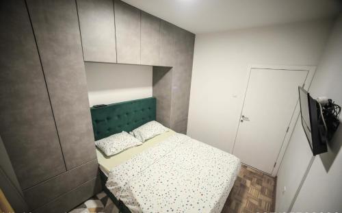 a small bedroom with a bed with a green headboard at Apartman Golemovic in Banja Luka