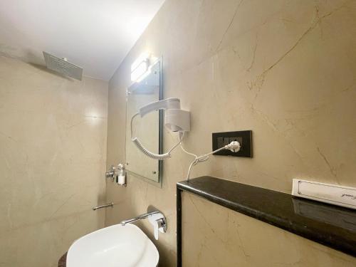 uma casa de banho com um lavatório e um espelho na parede em HOTEL SARC ! VARANASI - Forɘigner's Choice ! fully Air-Conditioned hotel with Lift & Parking availability, near Kashi Vishwanath Temple, and Ganga ghat 2 em Varanasi