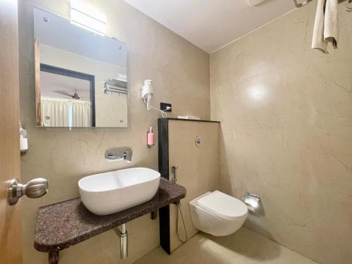 uma casa de banho com um lavatório e um WC em HOTEL SARC ! VARANASI - Forɘigner's Choice ! fully Air-Conditioned hotel with Lift & Parking availability, near Kashi Vishwanath Temple, and Ganga ghat 2 em Varanasi