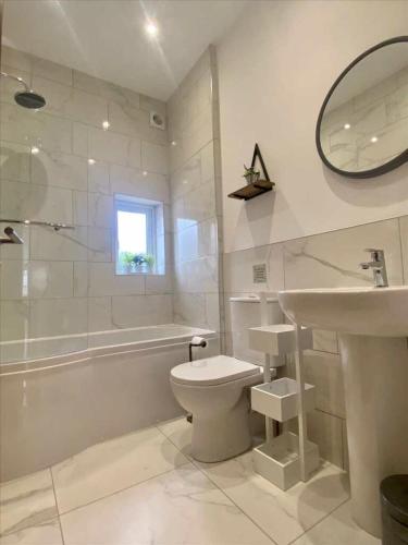 a white bathroom with a toilet and a sink at Brooklands Filey Seaside Retreat Flat 6 in Filey