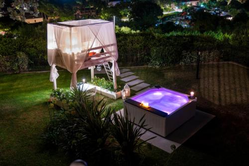 a jacuzzi tub in a backyard at night at Tra gli Alberi e il Mare in Sirolo