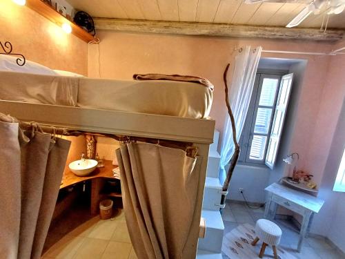 a room with two bunk beds and a window at Casaluna, chambre climatisée dans maison de village in Sotta