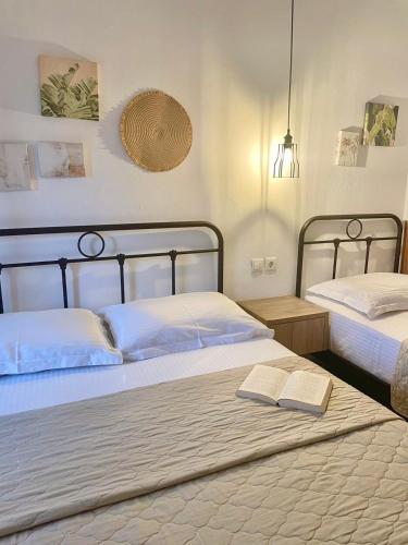 a bedroom with two beds and a book on the bed at House Marianthi Anthoula in Sarti