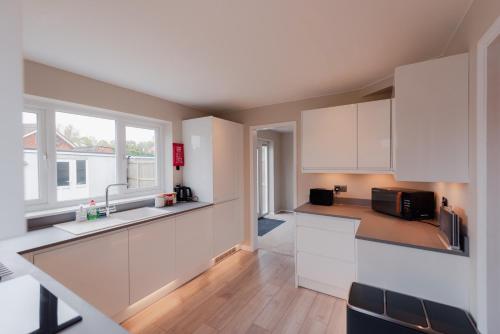 a kitchen with white cabinets and a window at Luxury Recently Renovated 3 Bedroom home in Sandwich Kent in Sandwich