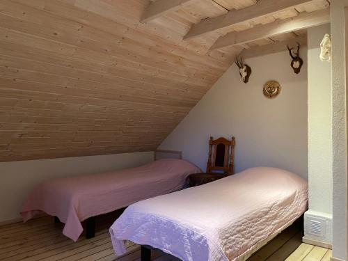 two beds in a attic room with wooden ceilings at Ööbiku Holiday House in Antsla