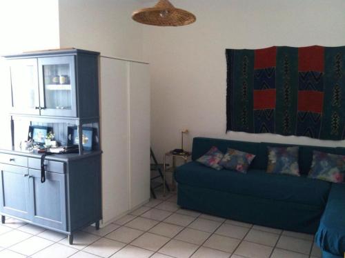 ein Wohnzimmer mit einem blauen Sofa und einem Schrank in der Unterkunft Appartamento con vista incantevole sul mare in Chiesa Vetusa