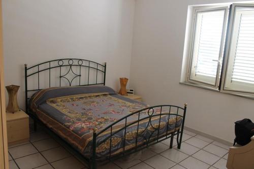 ein Schlafzimmer mit einem Bett mit einer Decke darauf in der Unterkunft Appartamento con vista incantevole sul mare in Chiesa Vetusa