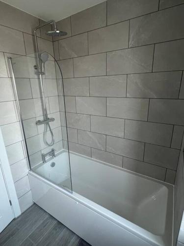 La salle de bains est pourvue d'une baignoire et d'une douche en verre. dans l'établissement House in Dorset, à Iford