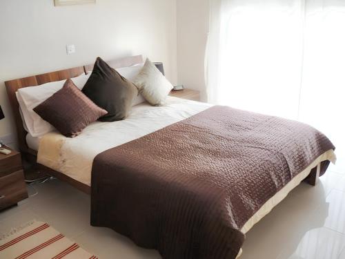 1 cama con almohadas en el dormitorio en 2 bedrooms apartement with shared pool furnished terrace and wifi at Larnaca 2 km away from the beach en Tersephanou