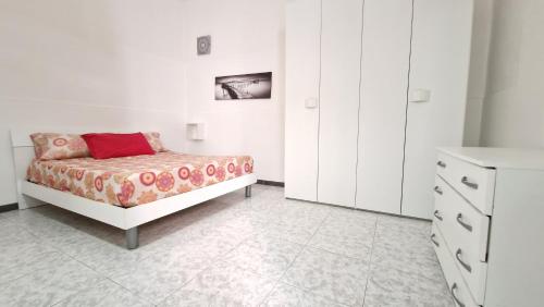 a white bedroom with a bed and a dresser at Economy Guest House in Gallipoli