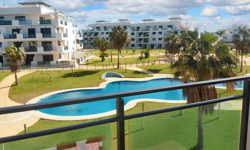 レタマルにある2 bedrooms apartement with shared pool and enclosed garden at Almeria 1 km away from the beachのバルコニーからスイミングプールの景色を望めます。