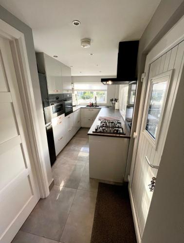 a kitchen with white cabinets and a stove top oven at The Little house with a Tub in Bangor