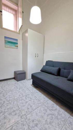 a living room with a blue bed and a window at Economy Guest House in Gallipoli