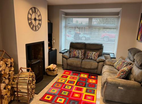 a living room with two couches and a fireplace at The Little house with a Tub in Bangor