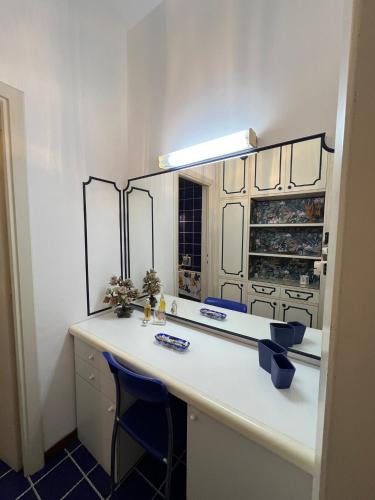 a bathroom with a vanity with a mirror and blue chairs at B&B I versi del mare in Roseto degli Abruzzi