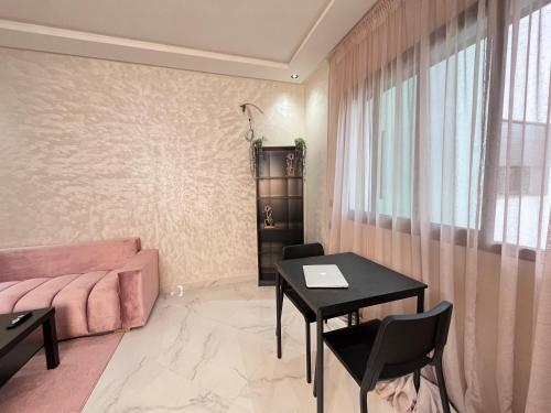 a living room with a table and a couch at Modern & Cosy Studio City Center in Kenitra