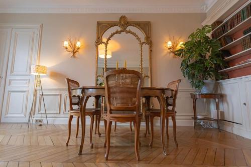une salle à manger avec une table, des chaises et un miroir dans l'établissement Apt vue Louvre et Seine, à Paris