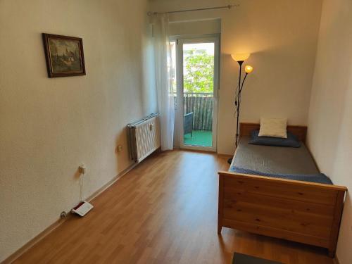 Schlafzimmer mit einem Bett und einer Tür zu einem Balkon in der Unterkunft 3 min walk to Bahnhof -Peaceful room with Balcony in Mannheim