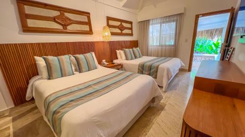 a hotel room with two beds and a window at Viva Dominicus Beach by Wyndham, A Trademark All Inclusive in Bayahibe