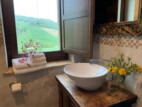 a bathroom with a sink and a window with towels at Casa Raphael, Amandola in Amandola