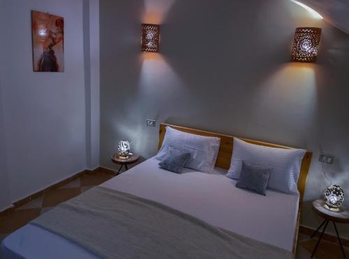 a bedroom with a white bed with two lamps at Lighthouse Apartment in Dahab