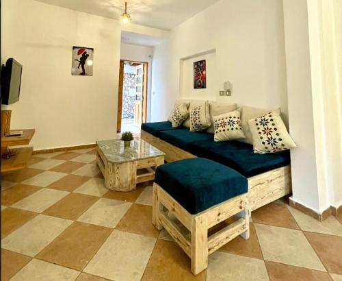 a living room with a blue couch and a table at Lighthouse Apartment in Dahab