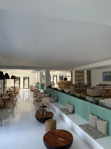 een lobby met tafels en stoelen en een cafetaria bij Cavo piso livadi in Piso Livadi