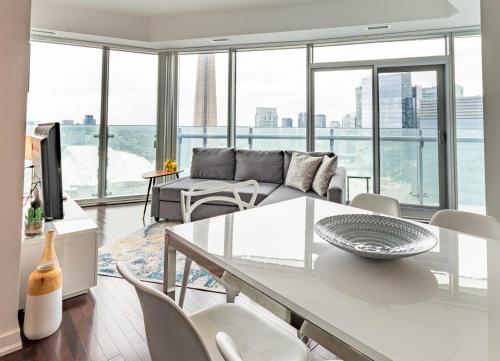 a living room with a couch and a table and chairs at High Rise Condo with Stunning Lake and CN tower view in Toronto