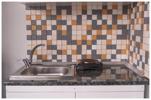 a kitchen counter with a sink and a tiled wall at Last Point Süit Apart in Eskisehir