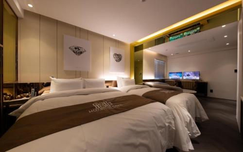 a large bedroom with two beds and a television at Hotel in Cafe Doksan in Seoul