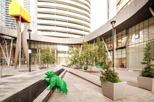 a green dinosaur statue in front of a building at High Rise Condo with Stunning Lake and CN tower view in Toronto