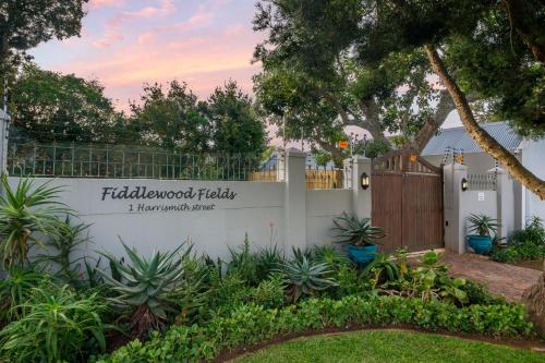 a white fence with a sign that reads filoli wood facility at Fiddlewood Fields Guest House in Grahamstown