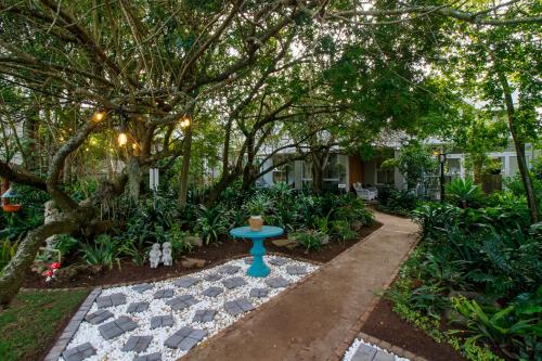 a garden with a blue bird bath in a yard at Fiddlewood Fields Guest House in Grahamstown