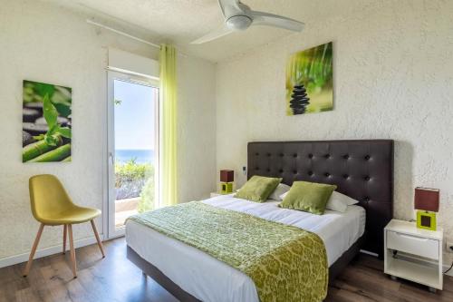 a bedroom with a large bed and a window at Résidence Marine de Palumbare in LʼÎle-Rousse