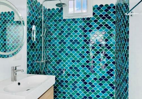 a blue tiled bathroom with a sink and a shower at Canaryislandshost I Marino in Famara