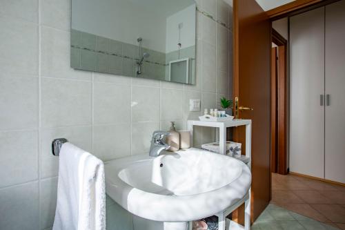 a bathroom with a white sink and a mirror at Lake Como Getaway - Central, Lake nearby - Parking & private garden in Mandello del Lario