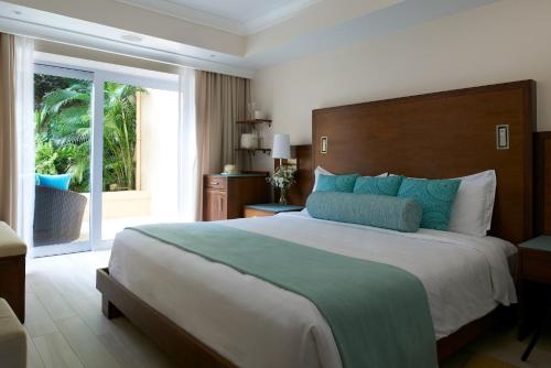 a bedroom with a large bed and a large window at BodyHoliday St Lucia in Gros Islet