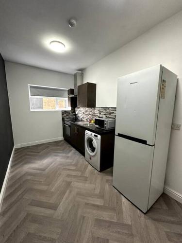 Il comprend une cuisine équipée d'un réfrigérateur blanc et d'une cuisinière. dans l'établissement 1 bedroom kitchen Flat, à Nottingham