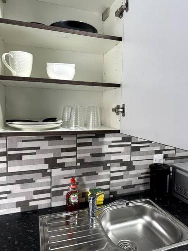 a kitchen counter with a sink and plates and dishes at 1 bedroom kitchen Flat in Nottingham