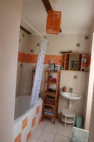 une salle de bain avec une baignoire et un lavabo dans l'établissement Maison aux volets rouges, à Tournemire
